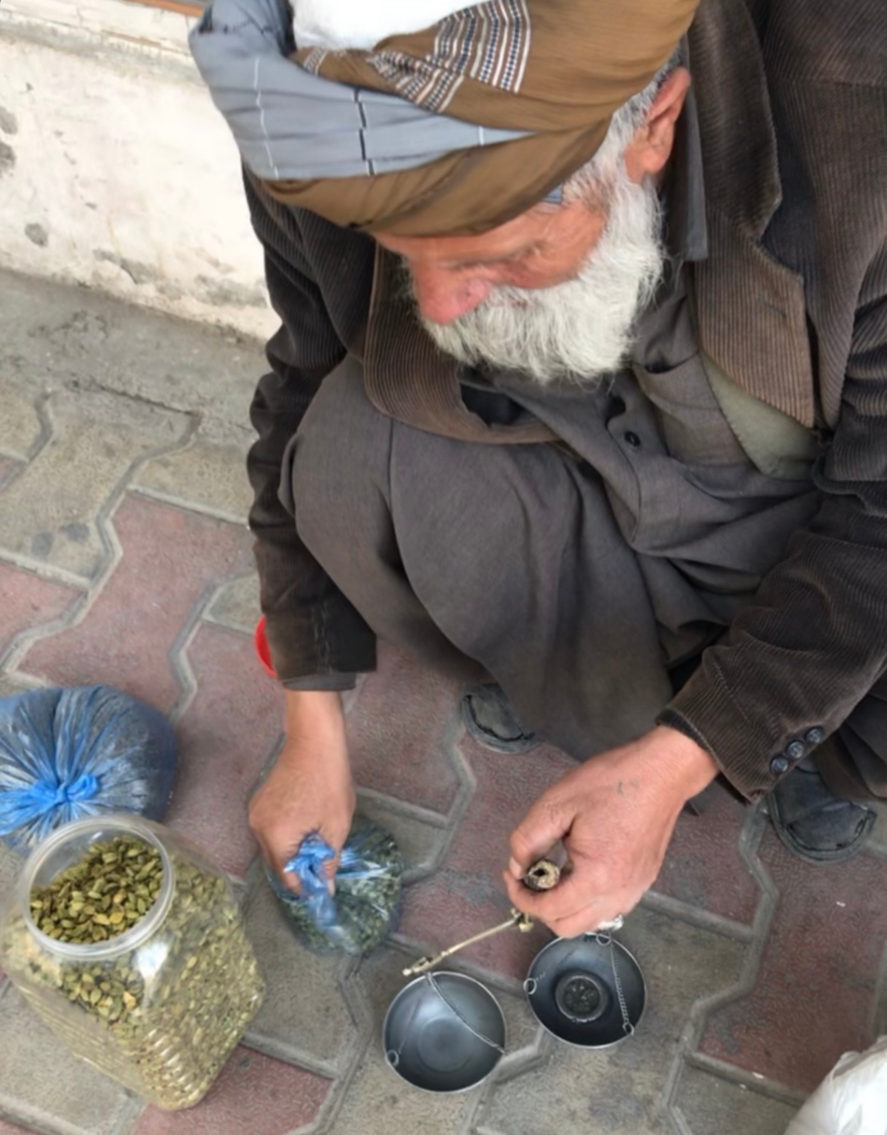 Elderly man in Afghanistan Weighing cardamom for sale on the streets of Afghanistan Kabul